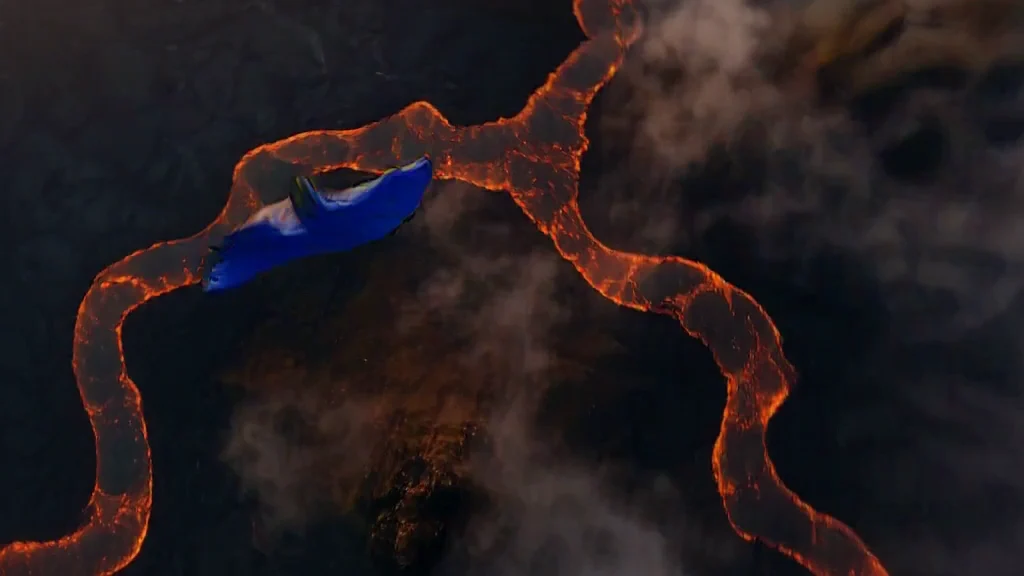 MiniMax H3 wingsuit flight above lava and ocean at sunrise